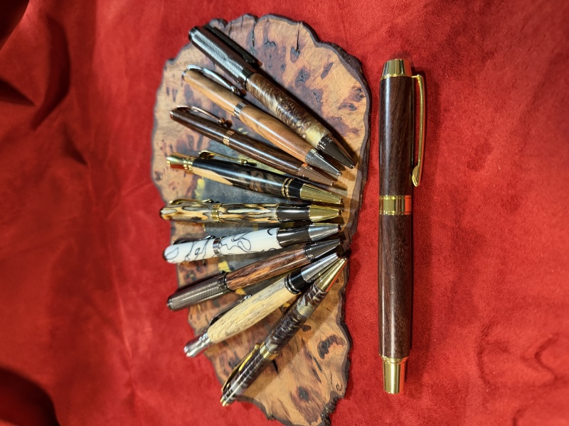 Various pen kits finished in resin and pine cones or cholla cactus, acrylic, and exotic woods.