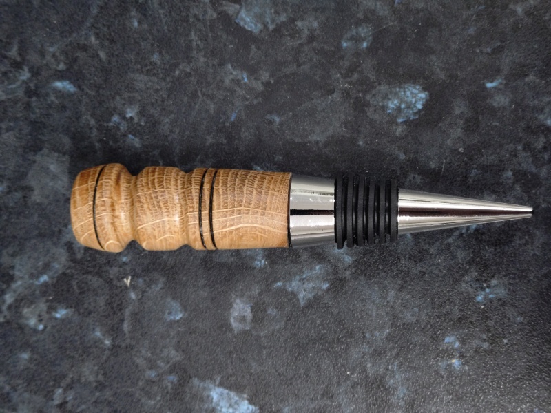 Bottle stopper hand turned from reclaimed whisky cask oak. Burn ring motif added and finished with friction wax.