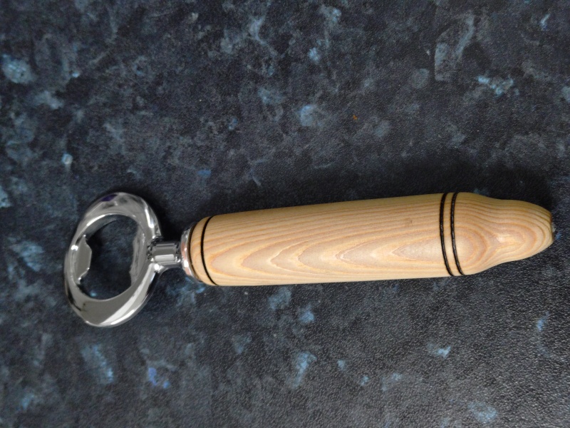 Bottle opener with a turned Ash handle with burned ring motif. The handle is finished with friction wax.